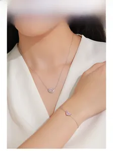 Detailed view of S925 sterling silver pink crescent necklace and bracelet set on model