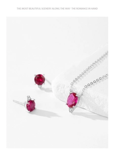 Detail showing 925 silver necklace with oval red ruby pendant and matching stud earrings