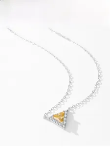 Macro shot of silver necklace with triangle yellow gemstone pendant and white diamond halo