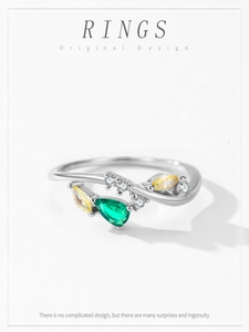Macro view of 925 sterling silver ring with emerald and yellow pear-cut gemstones