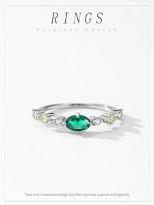 Macro view of marquise-cut emerald ring with sparkling gemstones in 925 silver