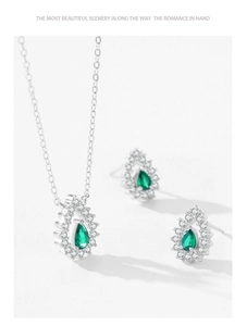Détail macro d'un ensemble collier et boucles d'oreilles en argent et pierre émeraude