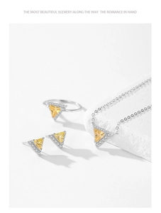 Close-up of 925 silver triangle yellow gemstone jewelry set on white textured stones