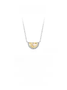 Detail of s925 silver necklace featuring a crescent pendant with yellow zircon and pavé diamonds