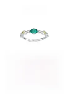 Macro detail of S925 silver ring featuring an oval green gemstone and colorful accents