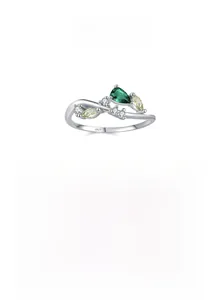 Macro detail of S925 sterling silver ring with emerald gemstone and leaf branch design