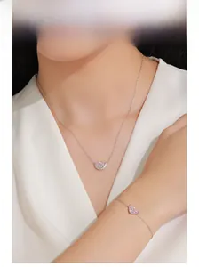 Primo piano di set collana e bracciale in argento 925 con pietre rosa su una modella