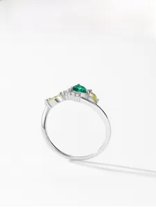 Macro detail of 925 silver ring featuring pear-cut emerald and yellow marquise stones