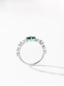 Macro shot of 925 silver ring with oval emerald gemstone and side stone detailing