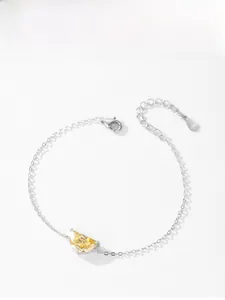 Macro shot of S925 sterling silver stamp and yellow crescent stone charm on the bracelet