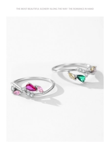 Macro shot of 925 silver rings with emerald cut green and red pear-shaped gemstones