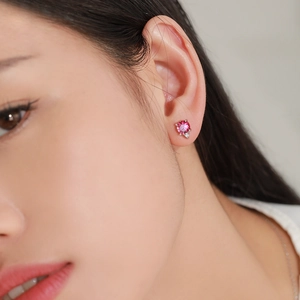 Orecchini a perno in argento 925 con gemma rosa e piccolo diamante su modella femminile