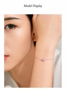 Detailansicht eines Silberarmbands mit rosa Zirkon und feiner Kette am Handgelenk