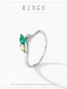 Détail macro d'une bague en argent avec pierre marquise verte et accents de gemmes jaunes