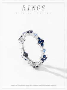 Primo piano di un anello d'argento con pietre blu scuro e azzurre alternate su bianco