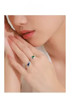 Close-up of S925 silver wavy rings with colorful gemstones on a female finger
