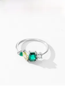 Macro detail of 925 silver ring featuring emerald-cut green and yellow zircon stones