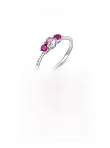 Gros plan d'une bague en argent 925 avec trois zircons roses sur fond blanc éclatant