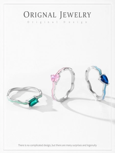 Detailed view of three 925 silver wavy rings with colorful enamel and heart shaped zircon