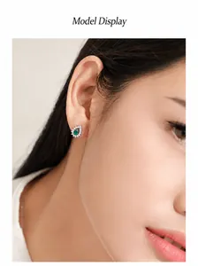 Dettaglio degli orecchini in argento sterling con smeraldo a goccia su una modella