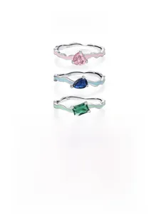 Macro detail of wave-shaped S925 silver rings with colorful enamel and zircon stones