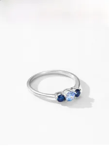 Vue détaillée d'une bague en argent S925 avec pierre centrale bleue et accents