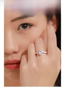 Close-up of heart-cut cubic zirconia ring with unique pink enamel coating on model's hand