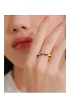 Gros plan d'une bague en argent 925 émaillé coloré sur le doigt d'un mannequin femme