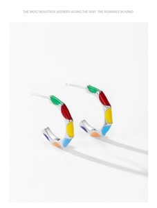 Vue macro de boucles d'oreilles créoles en argent 925 avec détails en émail arc-en-ciel
