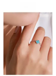 Vue macro de la bague chaine trèfle bleu en argent S925 portée sur un doigt