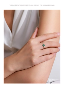 Primer plano de un anillo de cadena plateado con un trébol de cuatro hojas verde