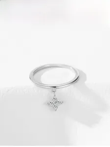 Macro detail of 925 silver ring featuring a sparkling four-leaf clover pendant with clear stones