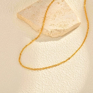 Détail d'une chaîne à maillons croisés dorée en acier inoxydable avec gravure florale