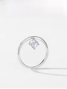 Macro detail of 925 sterling silver ring with a dangling heart-shaped diamond charm