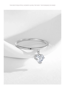 Detailed close-up of 925 silver heart charm ring with sparkling zirconia on white fabric
