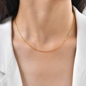 Collier minimaliste en acier inoxydable doré avec chaîne croisée plate sur un modèle
