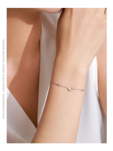 Dettaglio bracciale in argento S925 con ciondolo a mezzaluna e zirconi indossato al polso