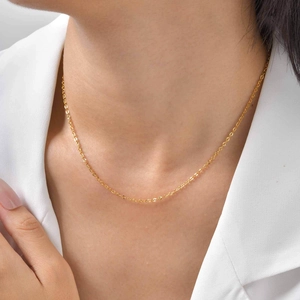 Gros plan d'un collier chaîne en acier inoxydable doré sur le cou d'un mannequin