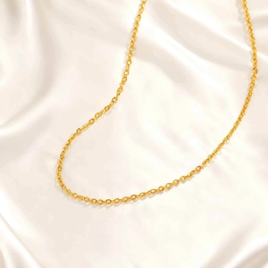 Collier chaîne croisée plate dorée pour femme sur fond de soie élégant