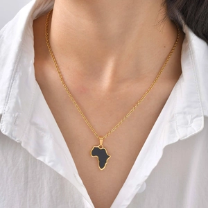 Goldene Afrika-Karte Halskette mit schwarzem Emaille-Inlay an einer Frau im weißen Hemd
