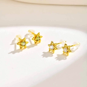 Vue détaillée des boucles d'oreilles hexagrammes en or avec zircons verts et clairs