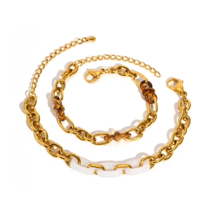 Détail du parure collier et bracelet dorés avec maillons en résine blanche et ambrée