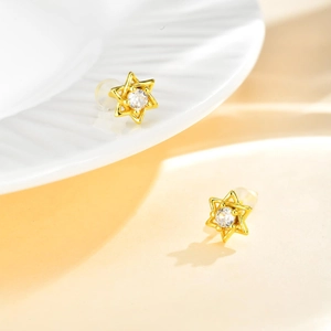 Détail de boucles d'oreilles hexagramme dorées avec zircon et fermoirs en silicone