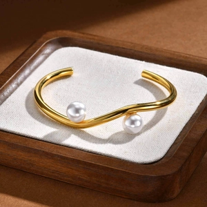 Golden irregular wavy open cuff bracelet with faux pearls in a minimalist geometric design