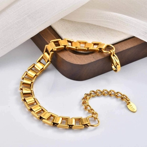 Macro detail of gold stainless steel link bracelet with lobster clasp and K18 hallmark tag