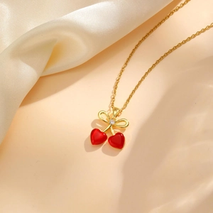 Collier cerise en cœur élégant avec nœud doré et zircon sur soie beige luxueux