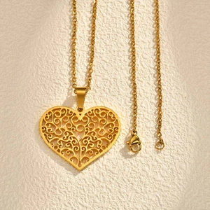 Detailed close-up of a gold hollow heart pendant with tree of life filigree patterns