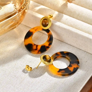 Close-up of vintage round tiger eye resin earrings in a luxury jewelry display box