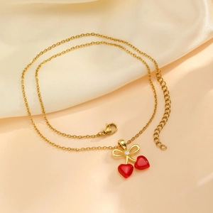 Élégant collier cerise doré avec pendentifs cœurs rouges et un détail de nœud délicat