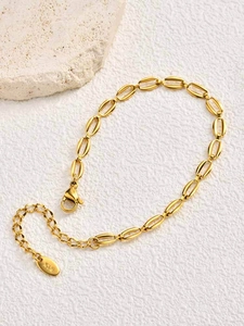Macro di una collana a catena dorata lucida con chiusura a moschettone e ciondolo rotondo